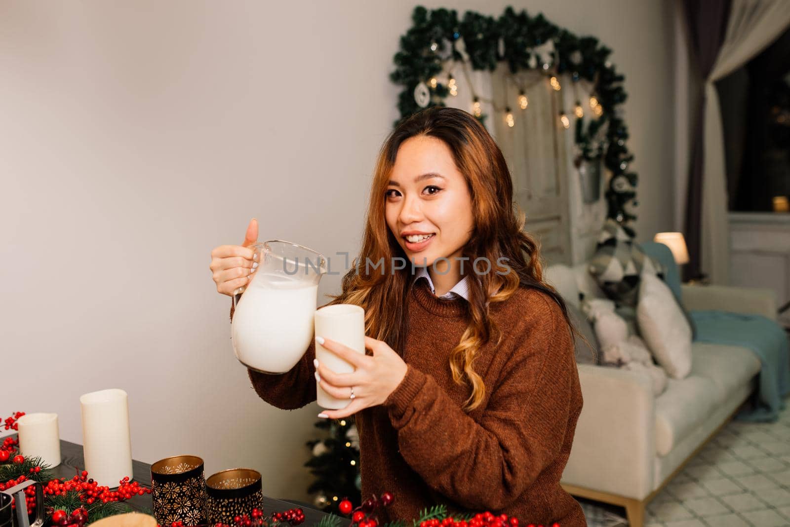 Beautiful young asian woman celebrating christmas at home, having fun opening presents