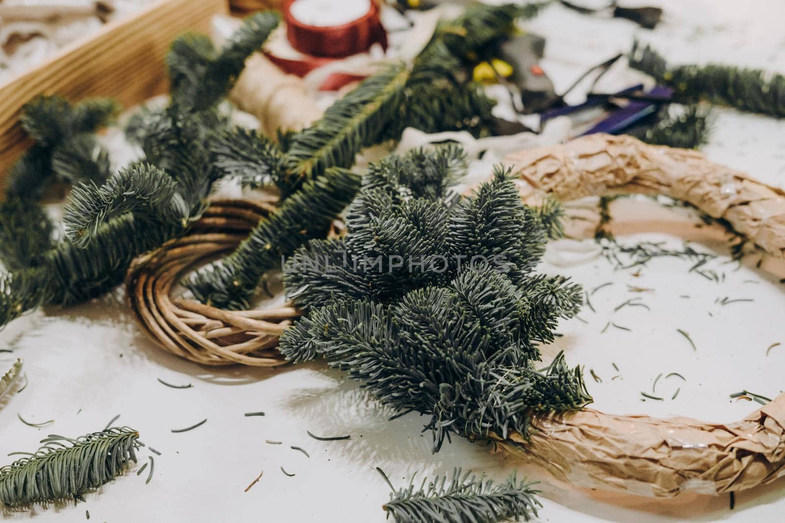 Creating a Christmas wreath of spruce branches and a cardboard frame. Craft paper. Decoration for the house for Christmas. Concept of florist's work before christmas holidays.
