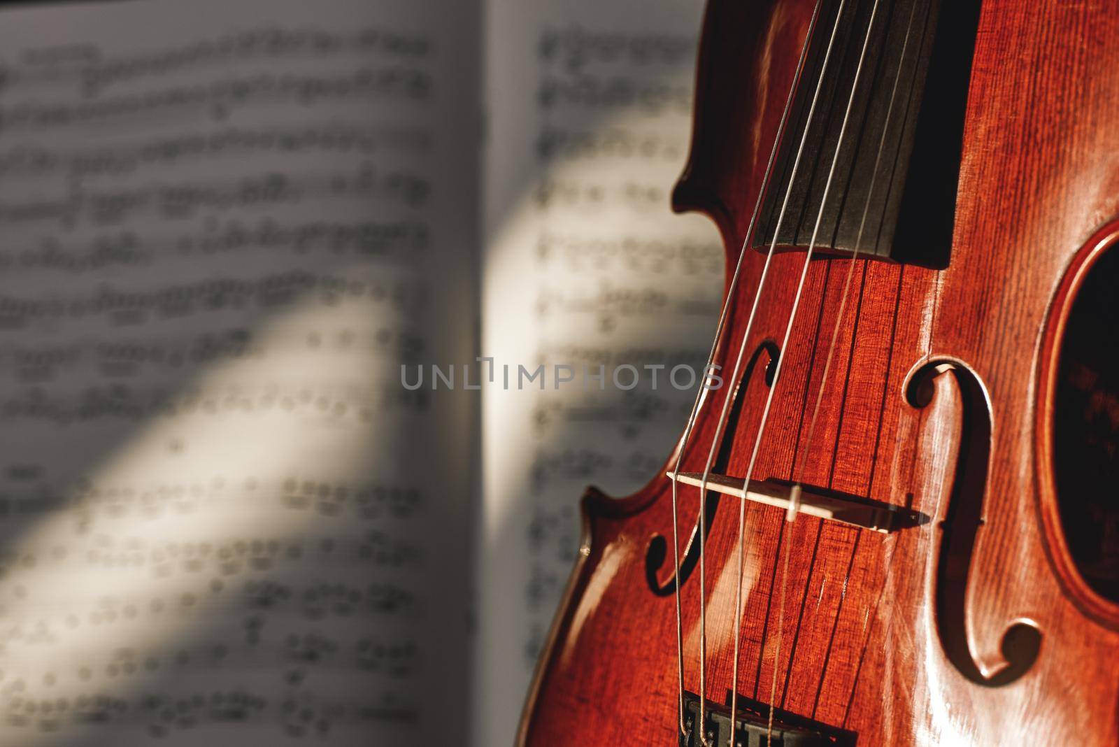 Preparing for a concert. Classic brown violin on music score sheet background. Musical instruments. Music equipment. Violin lessons