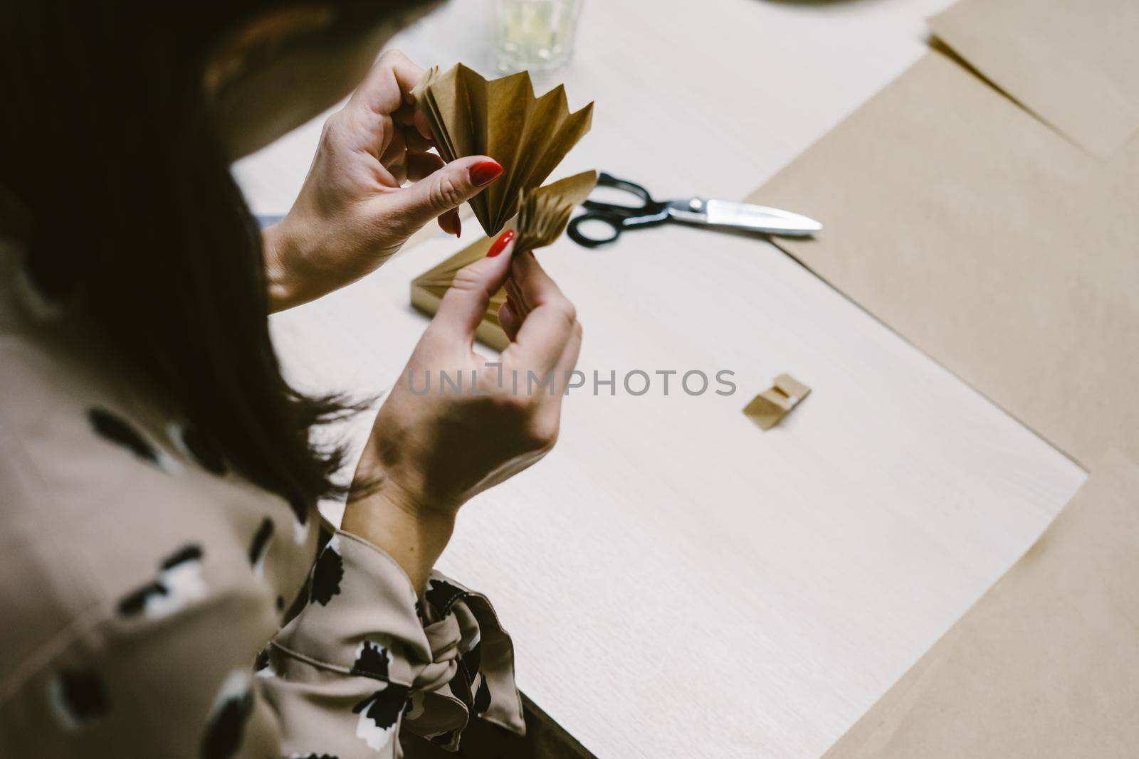 The origami stage. DIY personalized xmas decoration. Creating hand made christmas ornaments. Step by step instructions. Snowflake or three-dimensional star made of kraft paper.