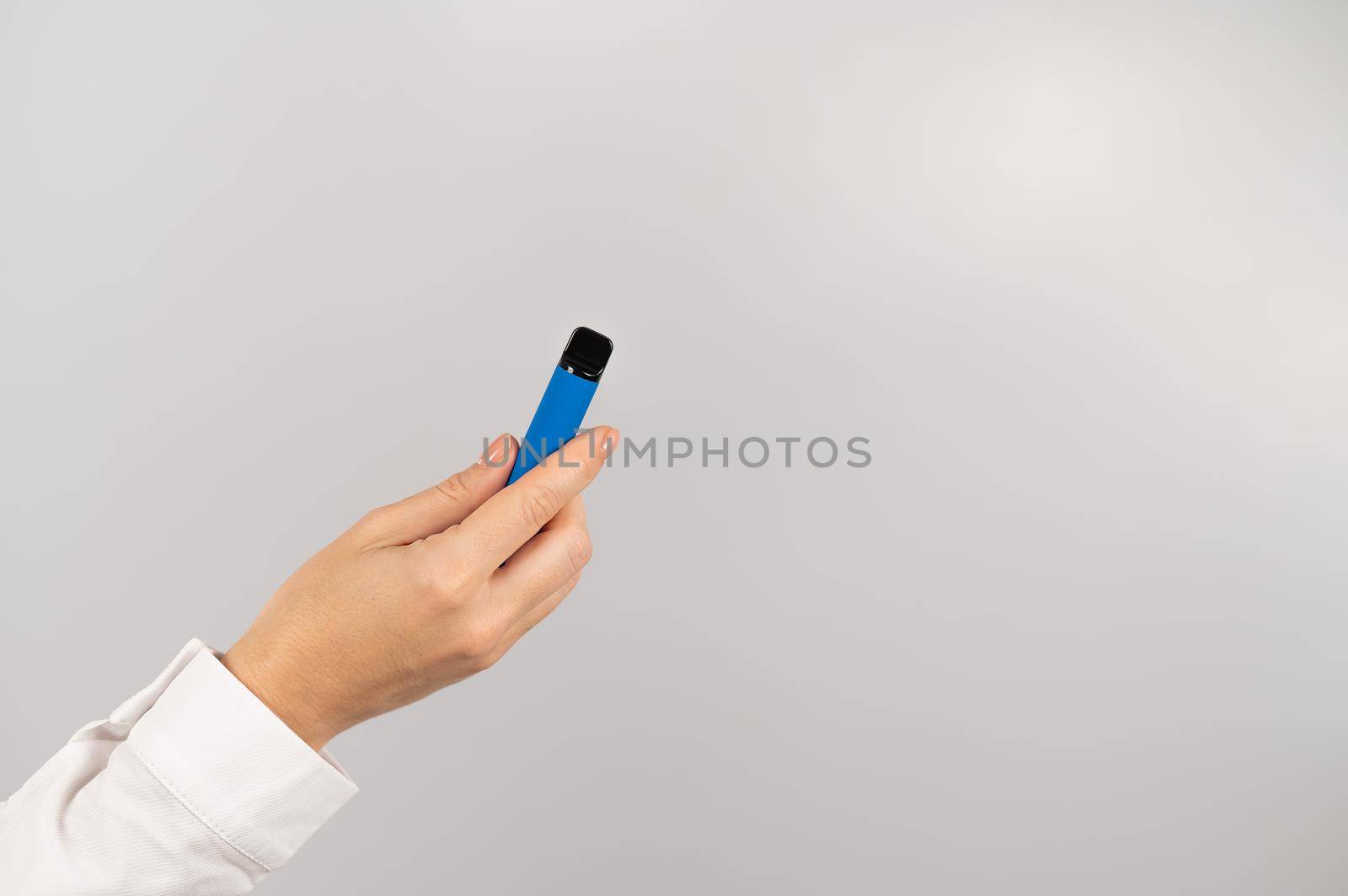 Faceless woman holding a disposable vape on a white background. by mrwed54