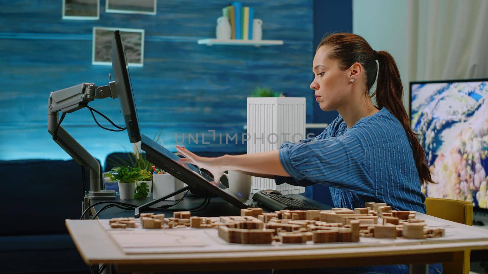 Architect using maquette for building model in office. Woman working as engineer with architectural equipment and touch screen monitor to design blueprint plan for construction layout