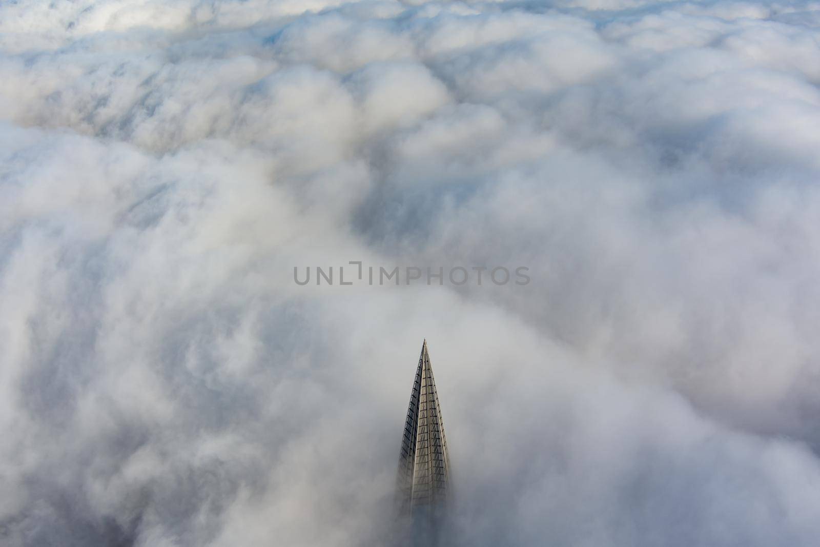 Russia, St. Petersburg, 14 October 2021: The top of the tallest skyscraper in Europe above the clouds, the building of the Gazprom oil company, the spire of a metal and glass structure. High quality photo