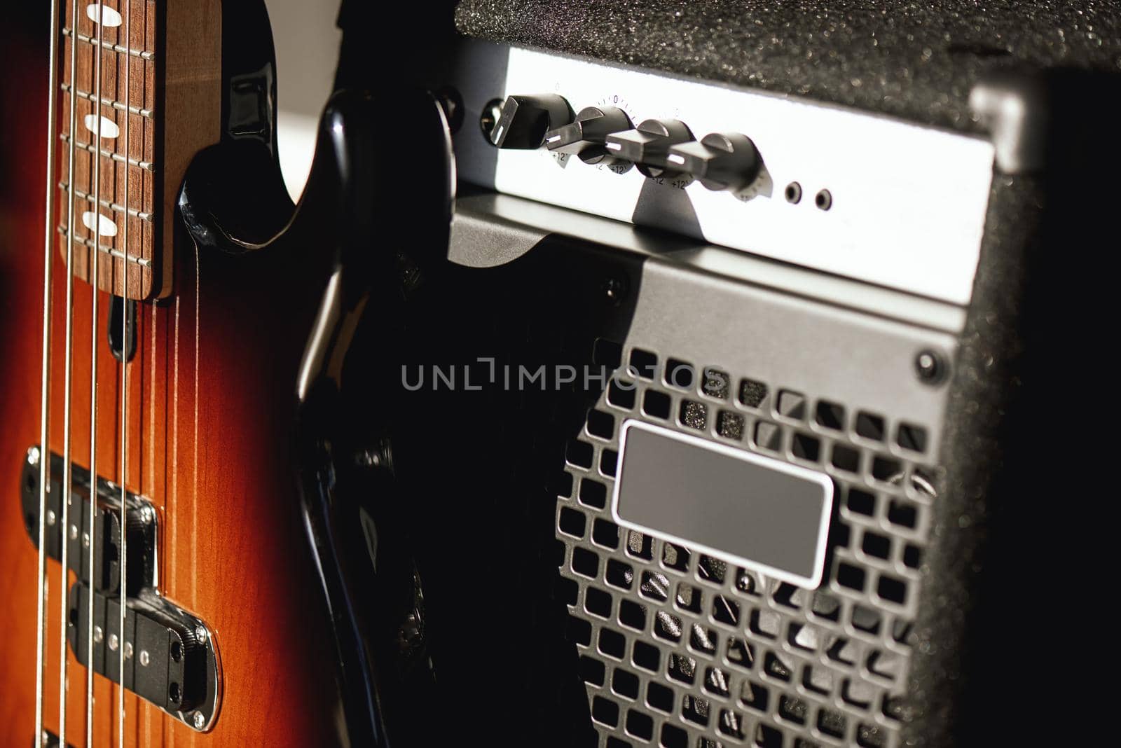 Beautiful and perfect polished electric guitar with amplifier standing in audio recording studio. Music recording. Music equipment. Musical instruments.