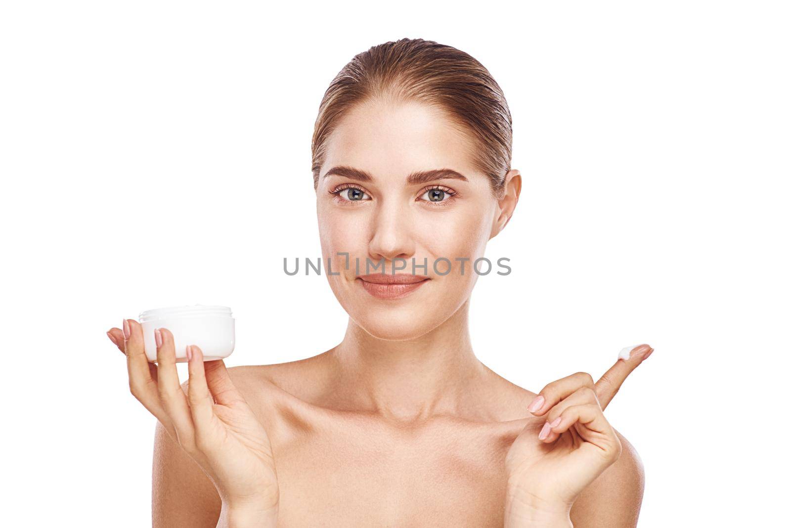 Beautiful womans face with facecream close up studio photo on white background. Light hair, grey eyes