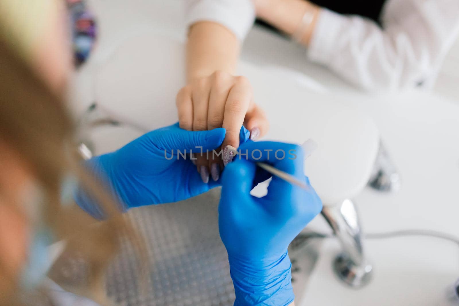 Female manicure master in beauty salon work with hands of the client