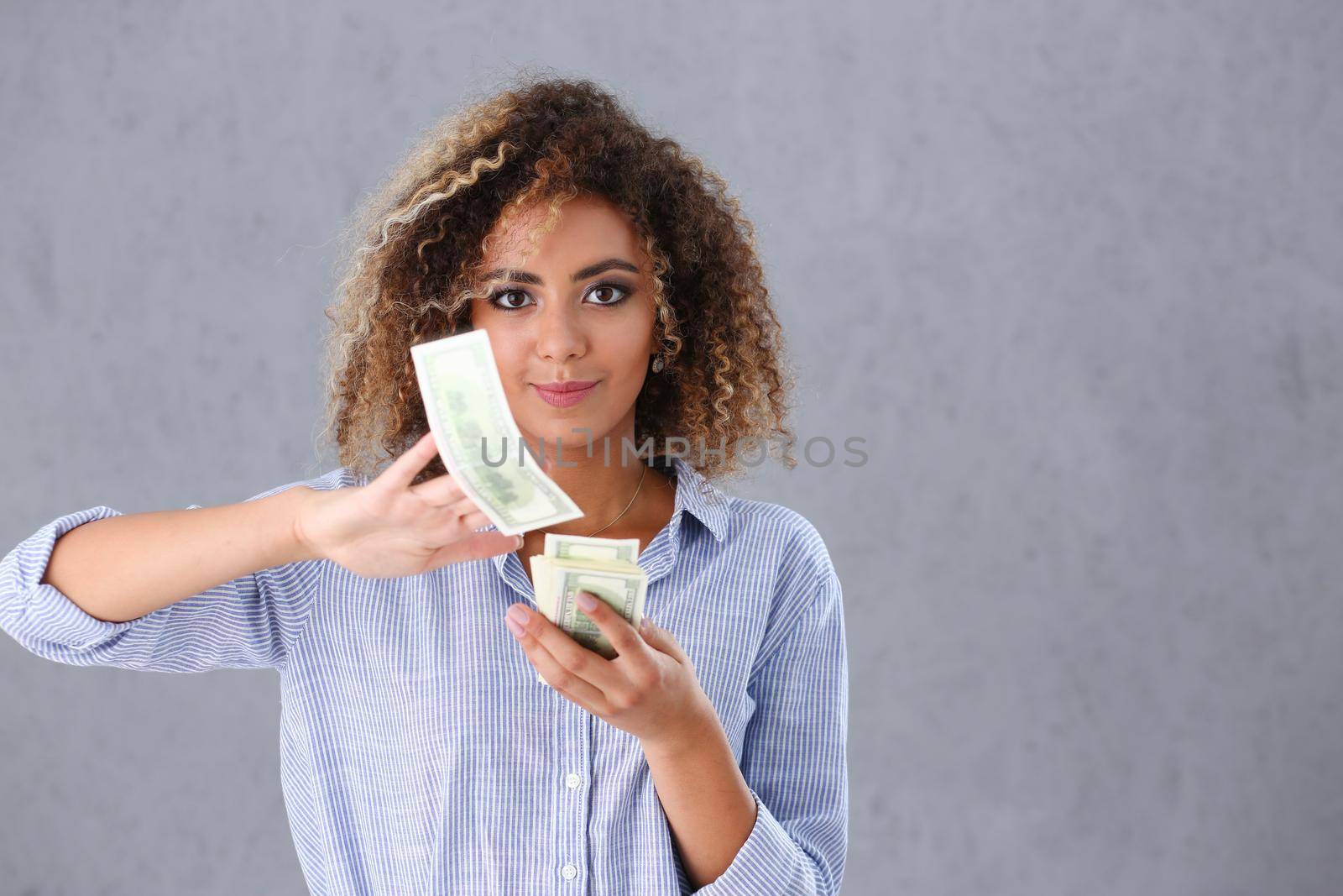 Beautiful black woman portrait. Scattering money notes dollars in fashion vows style curly hair with white locks eye view of the camera