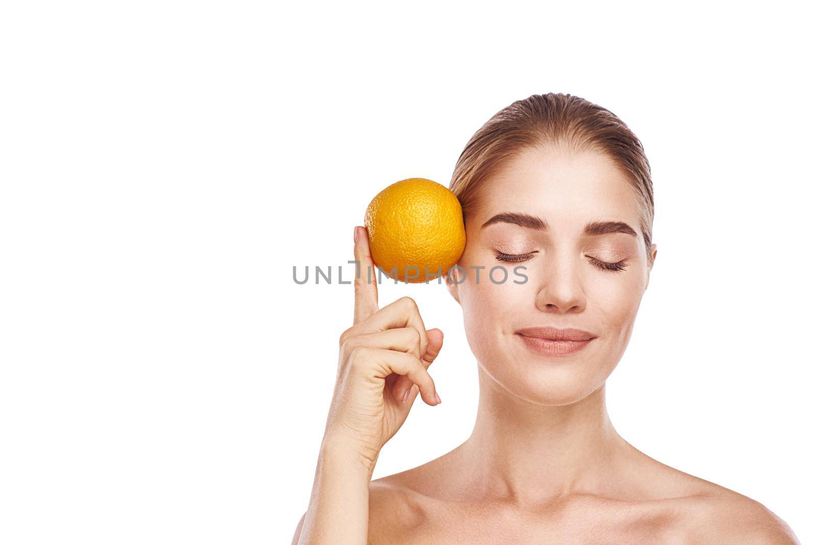 Beautiful womans face with orange close-up studio on white. by friendsstock