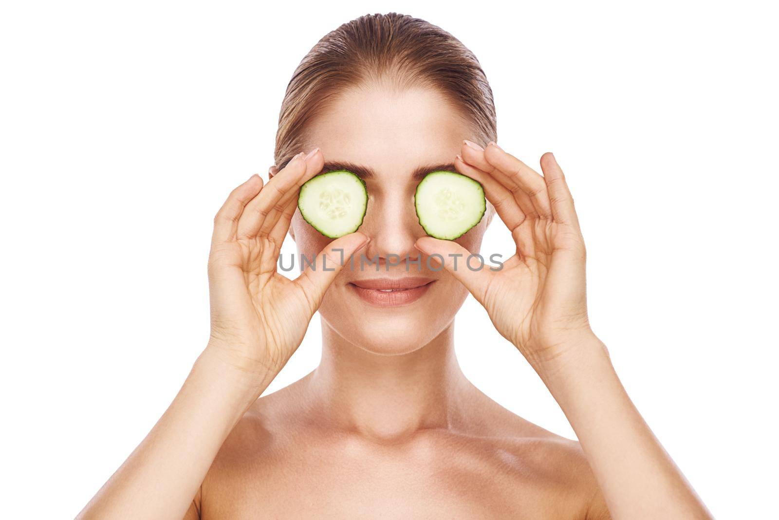 Beautiful womans face with cucumber close up studio photo on white background. Light hair, grey eyes, closed eyes