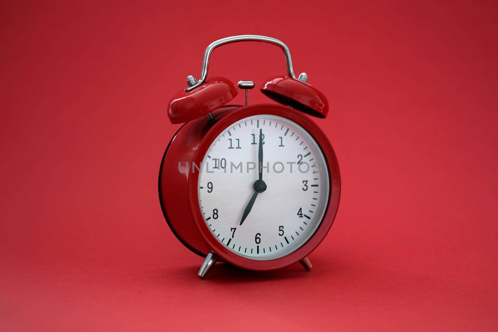 Vintage stylish alarm clock with bells on a red background, close-up. Planning and deadline. Productivity of the day