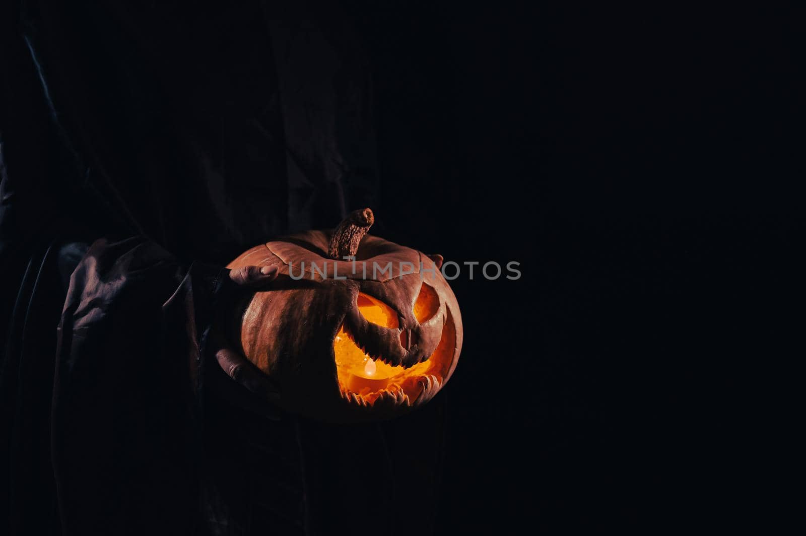 The witch is holding a pumpkin jack o lantern glowing in the dark. Halloween. by mrwed54