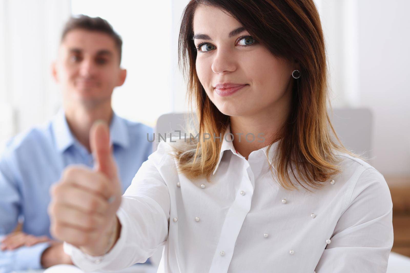 Female hand showing ok or approval sign with thumb up in creative people office during conference. High level and quality service job offer excellent education advisor serious business concept okay