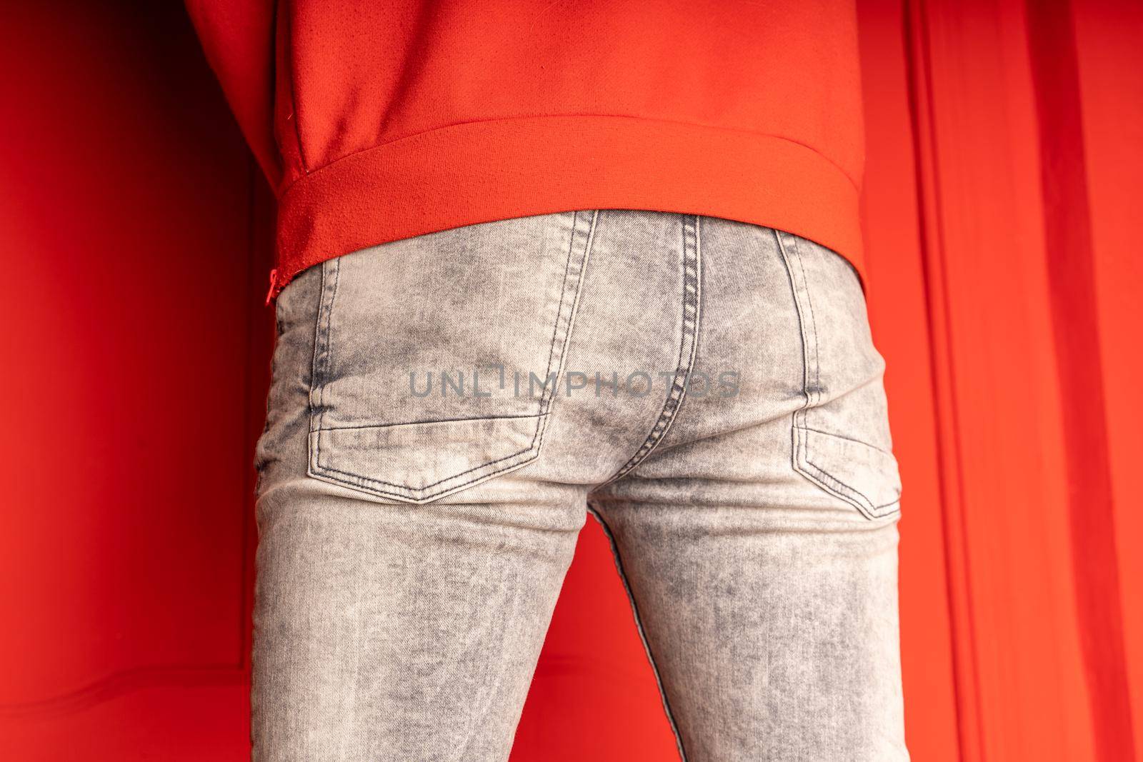 Close up of male buttocks in grey jeans. Rear view on buttocks of unrecognizable man