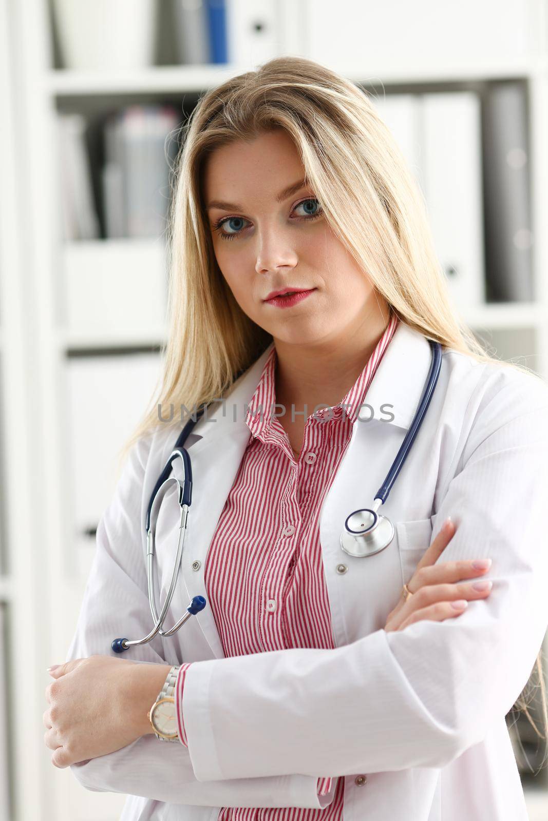 Beautiful smiling female doctor sit at workplace by kuprevich