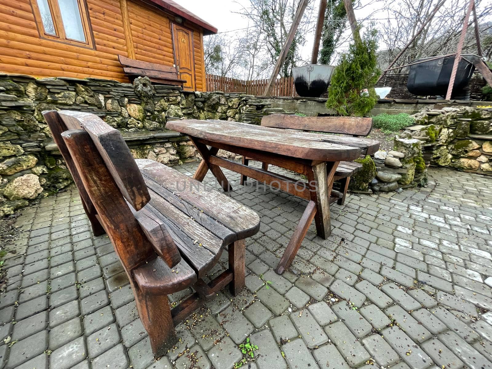 Close up of wooden table with benches in countryside. Log table and benches in empty village in cloudy weather