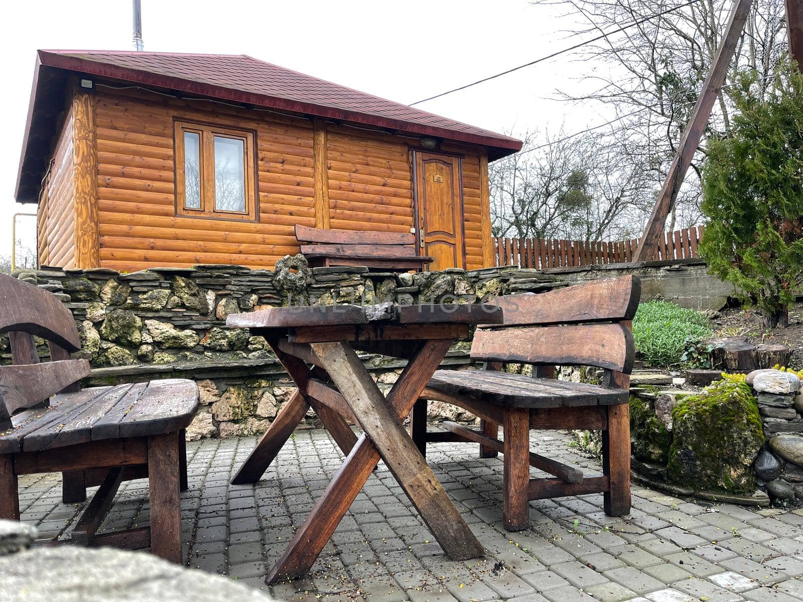 Close up of wooden table with benches in countryside. Log table and benches in empty village in cloudy weather