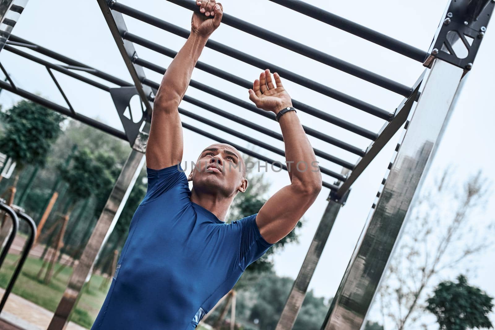 An african man is exercising at open air gym by friendsstock