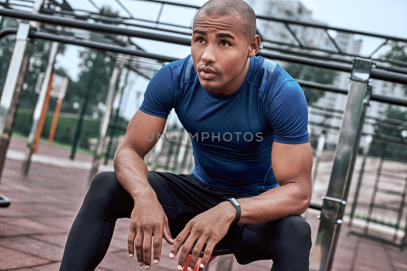 A little rest before exercises at open air. Close-up of black sportsman by friendsstock