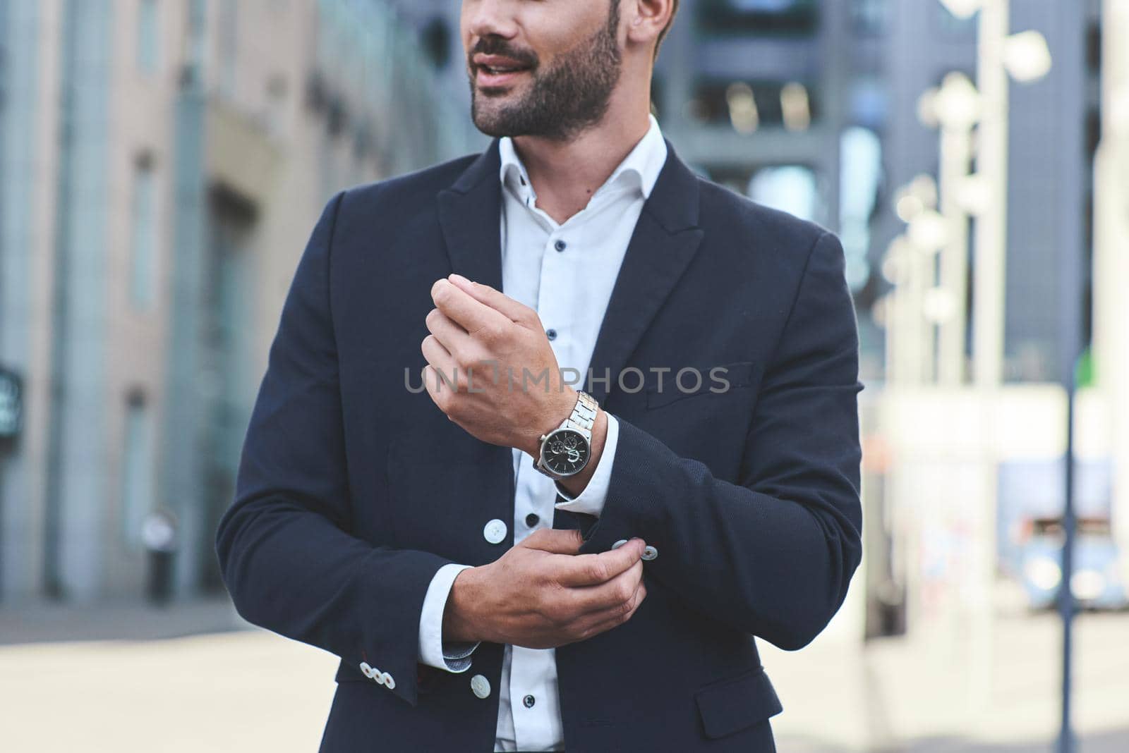 Confident businessman. Cropped shot of businessman in stylish suit straightens the sleeve by friendsstock