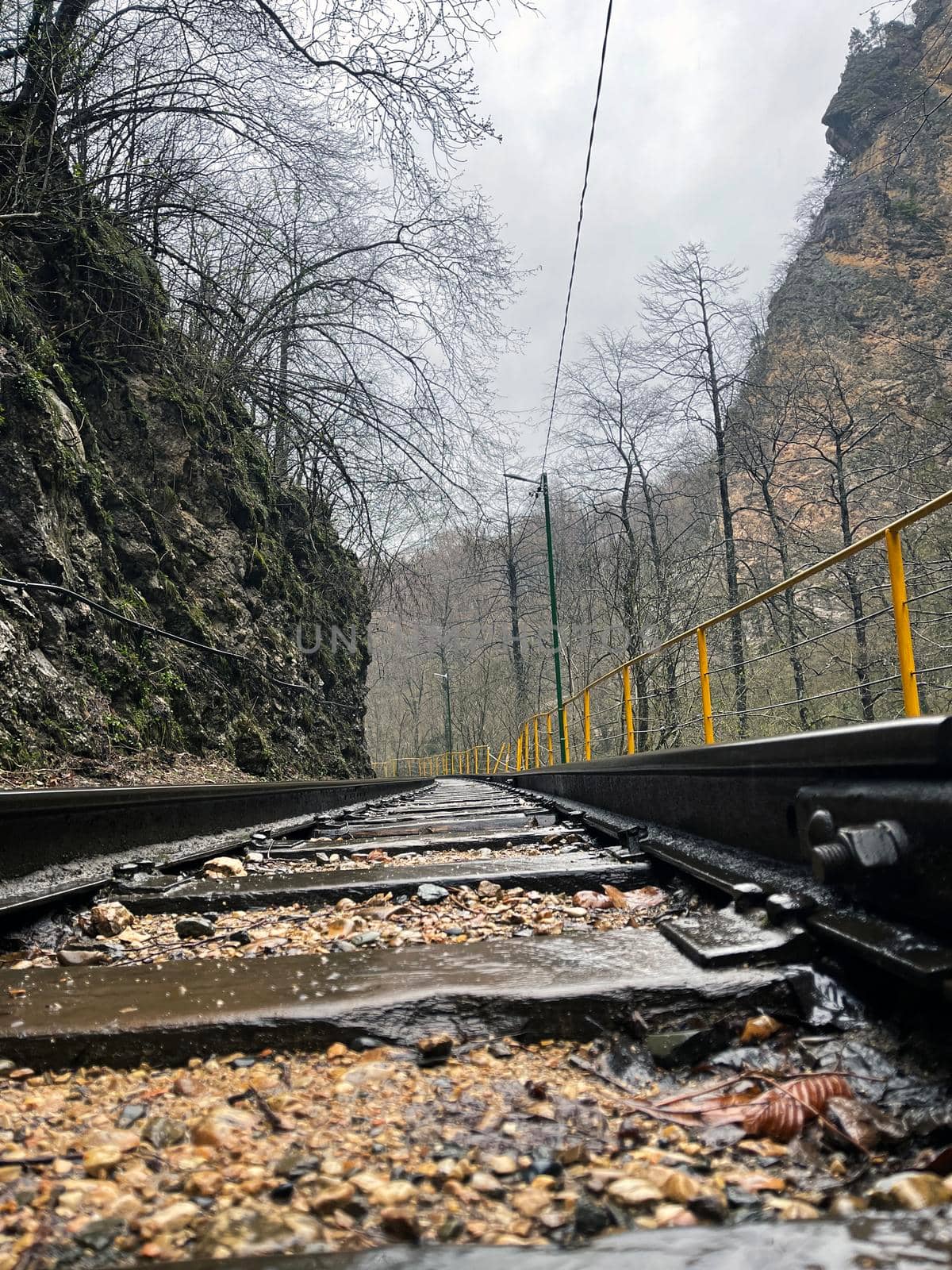 Close up of railway in mountainous terrain. Railway track in rainy weather in amazing and mysterious nature. by epidemiks