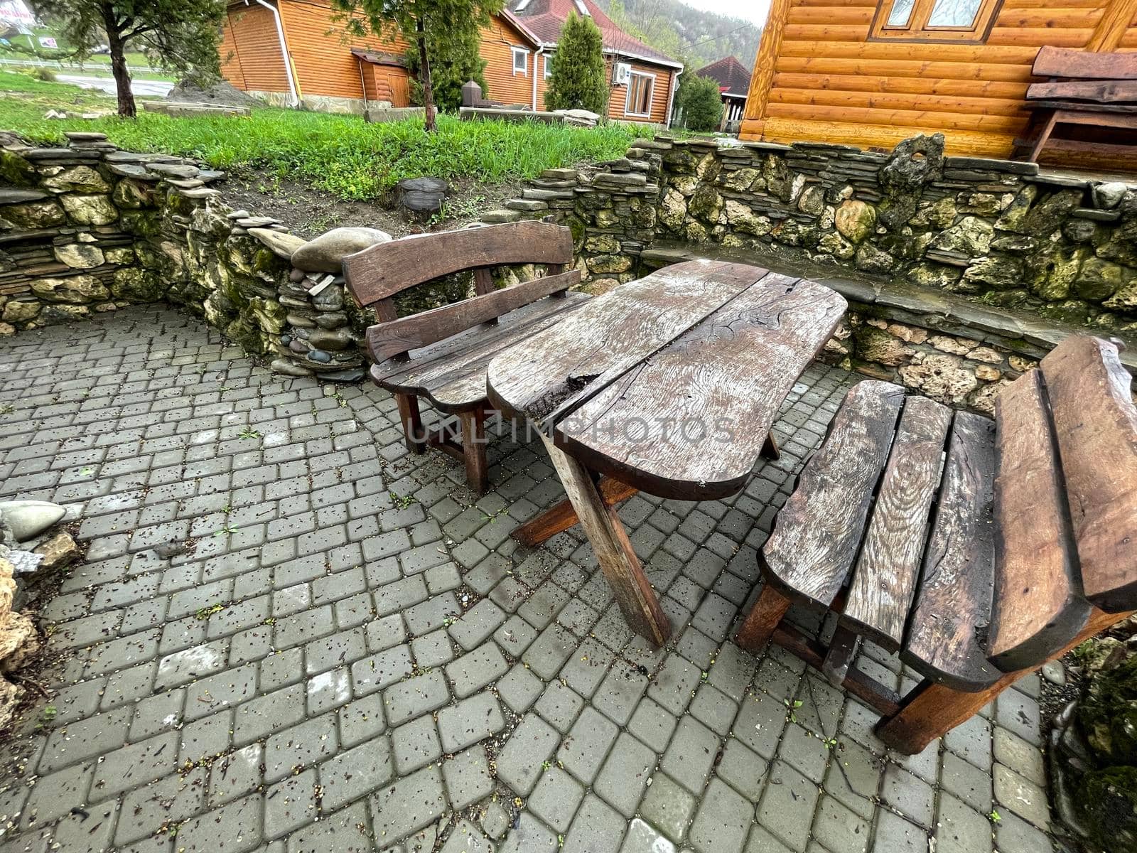 Close up of wooden table with benches in countryside. Log table and benches in empty village in cloudy weather. by epidemiks