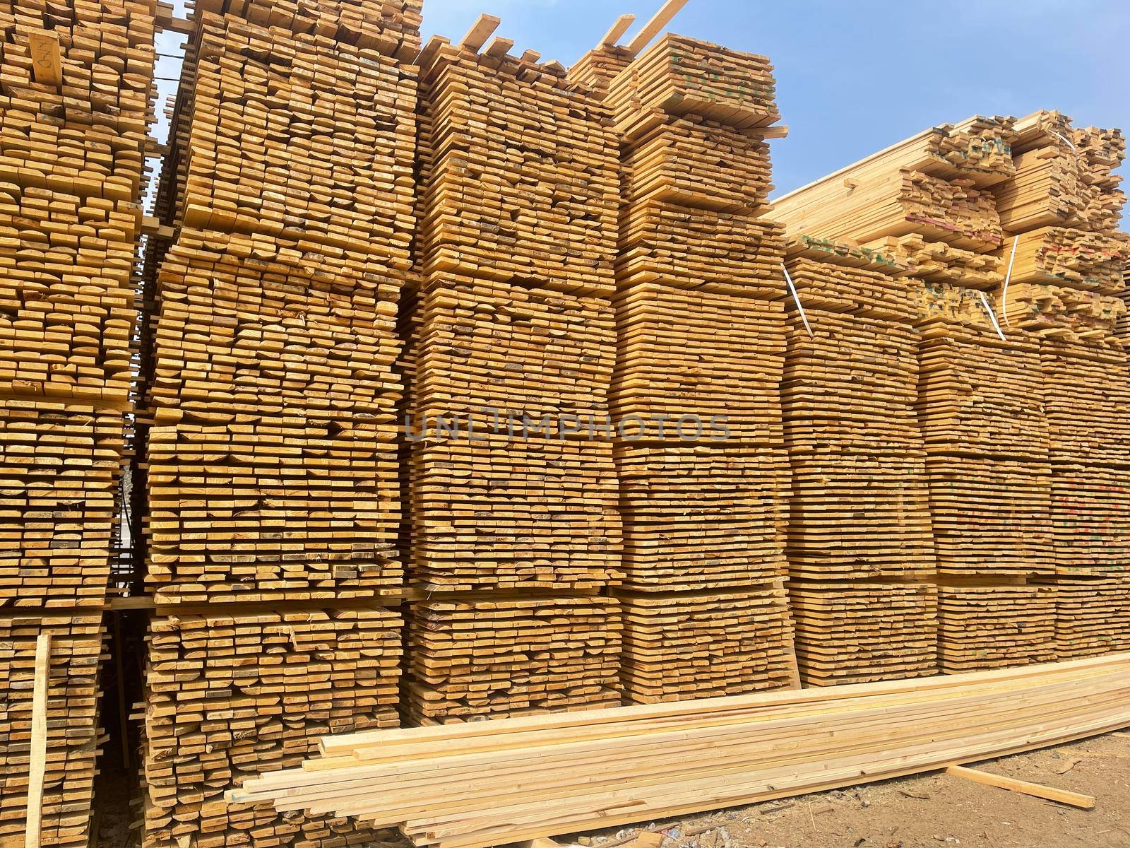 Close up of wooden boards on background of blue sky. Industrial natural timber building materials on building site