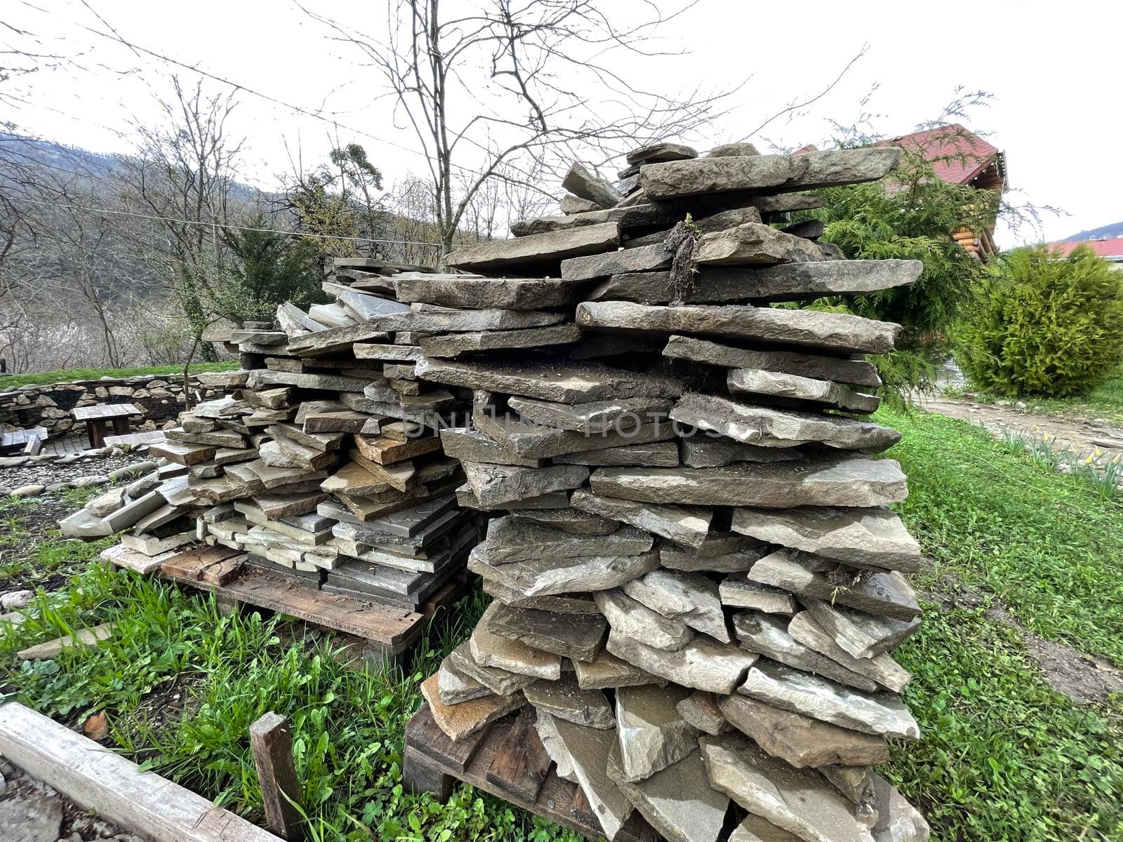 Pile of building materials on street in countryside. Close up of stone tiles on ground outdoor. Concept of constructing sidewalk. by epidemiks