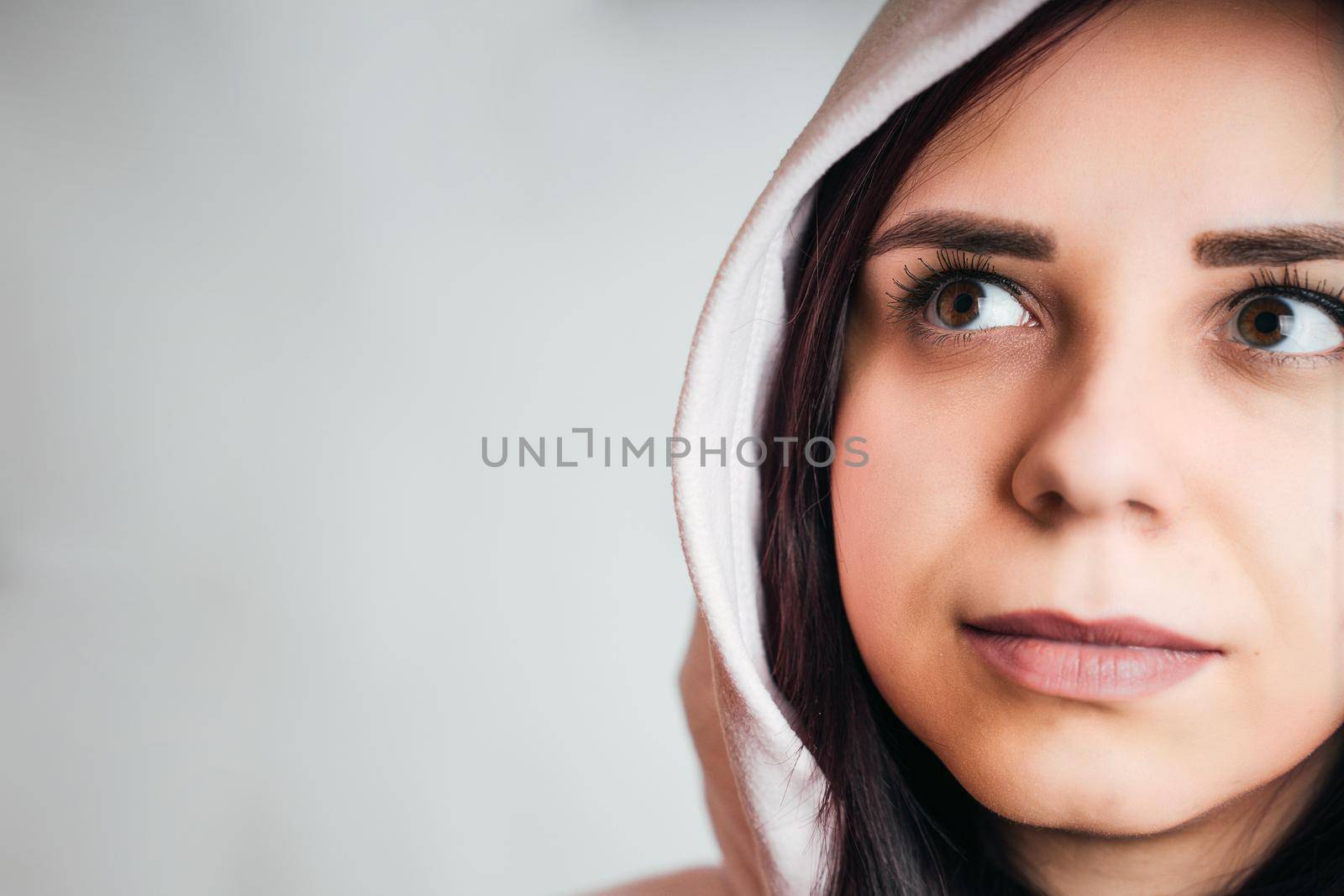 Portrait of thoughtful young woman on gray background with copyspace for your text. Close up of cute brunette looking away and reflecting about something. by epidemiks