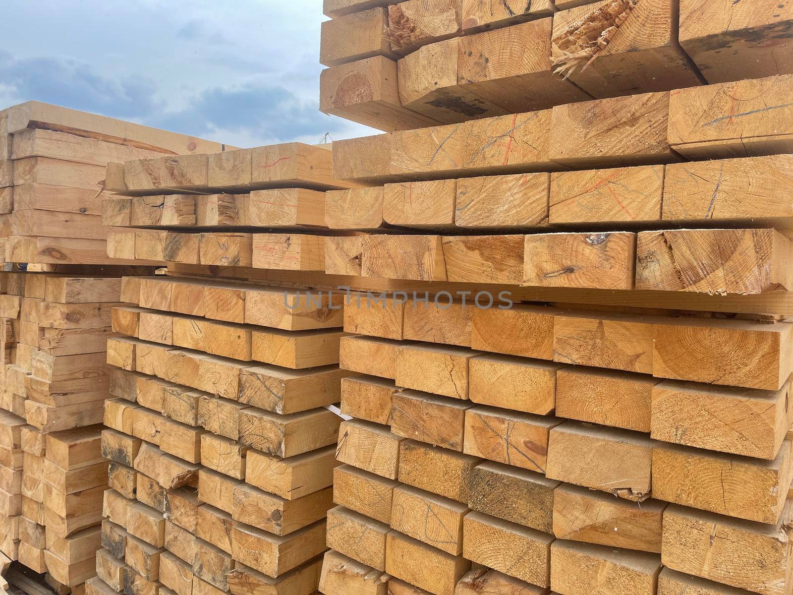 Close up of wooden boards on background of blue sky. Industrial natural timber building materials on building site