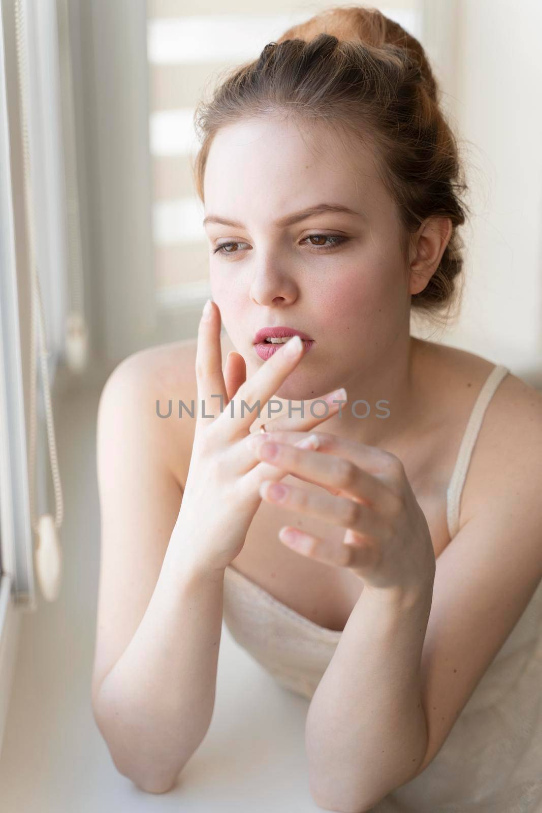 beautiful young woman is having relationship problems. the girl pulls the wedding ring on her finger