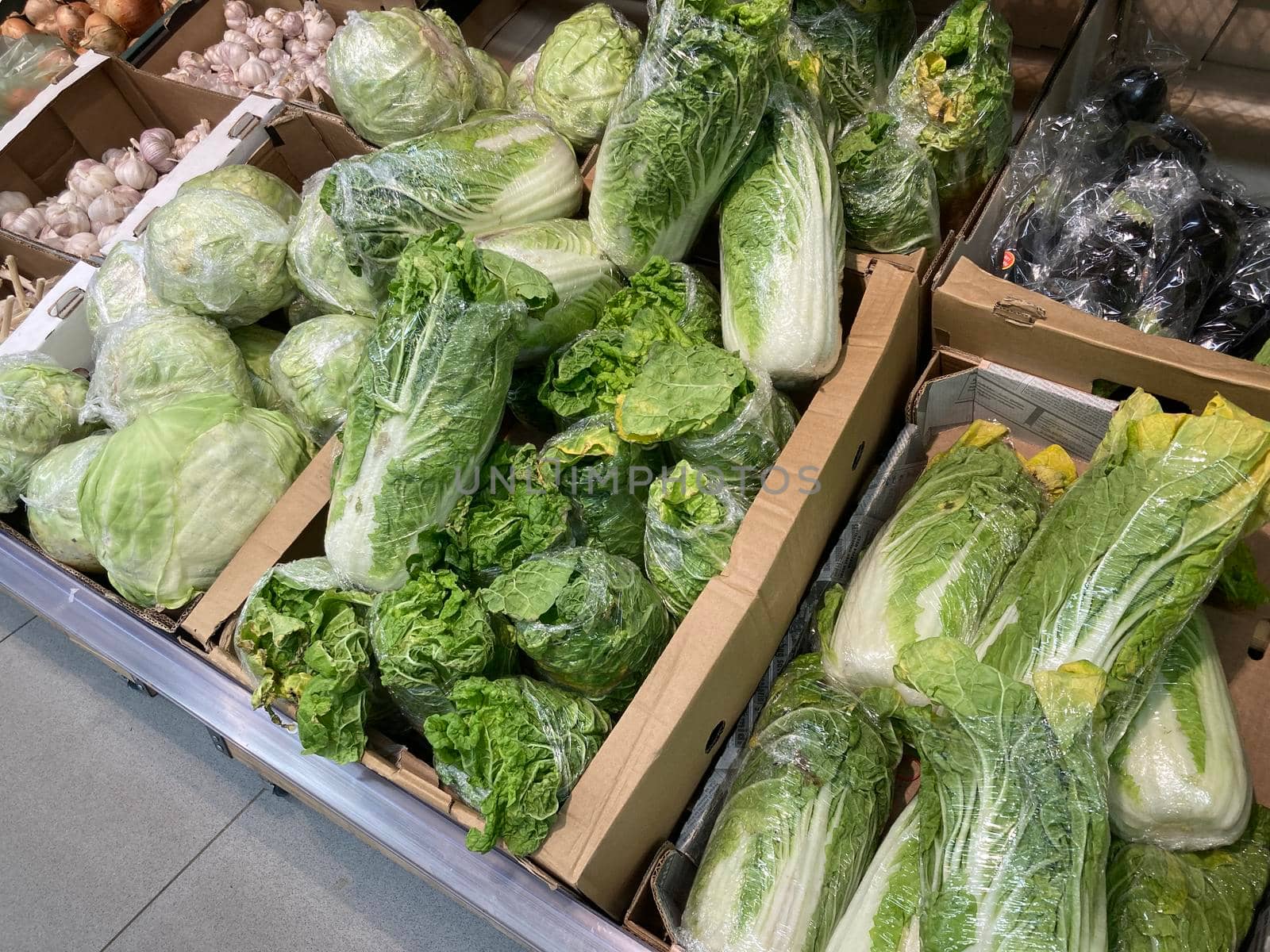 Close up of various cabbage in cardboard boxes on supermarket counter. Concept of agriculture, organic food, healthy eating and diet. by epidemiks