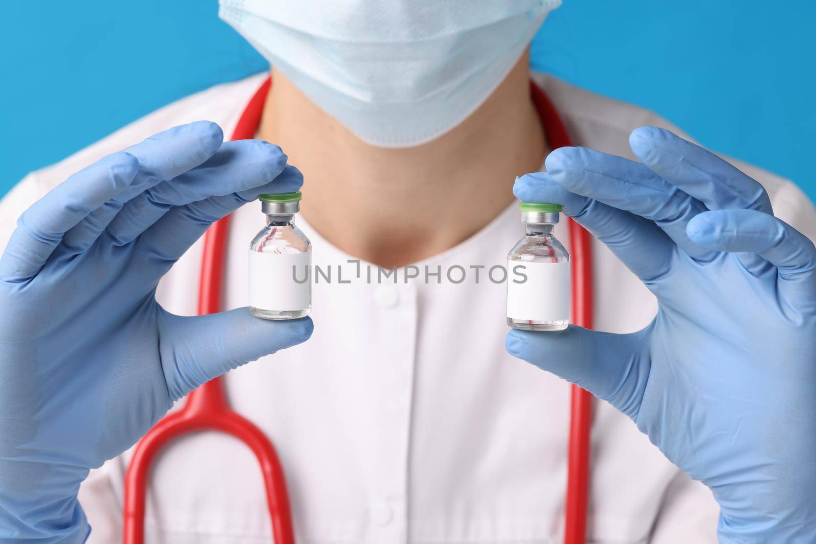 A nurse holds ampoules with medicine in her hands, close-up. Virus vaccine, immunization. Medication for infection, dose in a vial