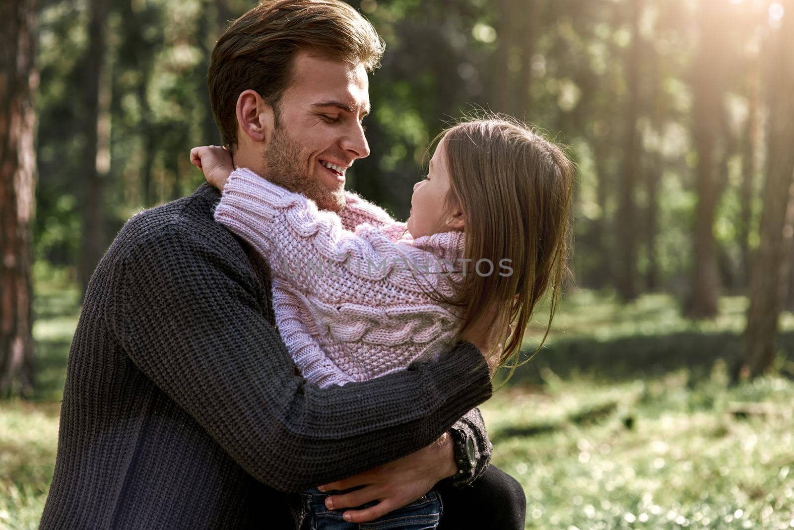 Little girl huggs her father in forest by friendsstock