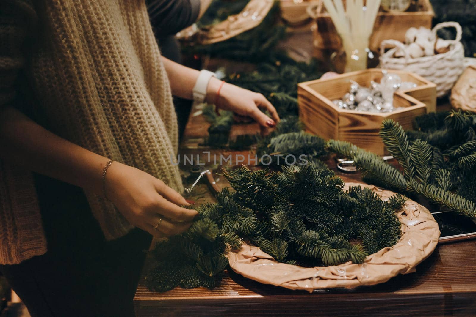 Creating a Christmas wreath of spruce branches and a cardboard frame. Craft paper. Decoration for the house for Christmas. Concept of florist's work before christmas holidays.