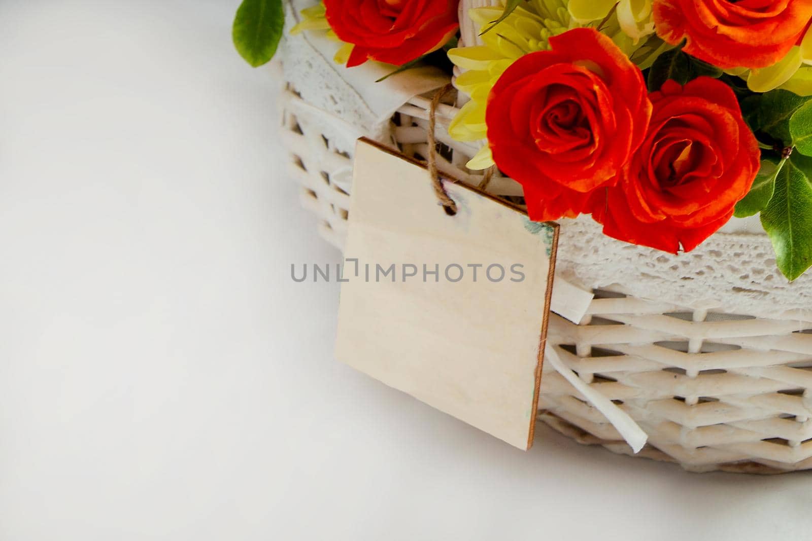 close-up greeting card on a white basket with scarlet roses and yellow chrysanthemums. white background for cutting. card blank for the inscription copy space by Mariaprovector