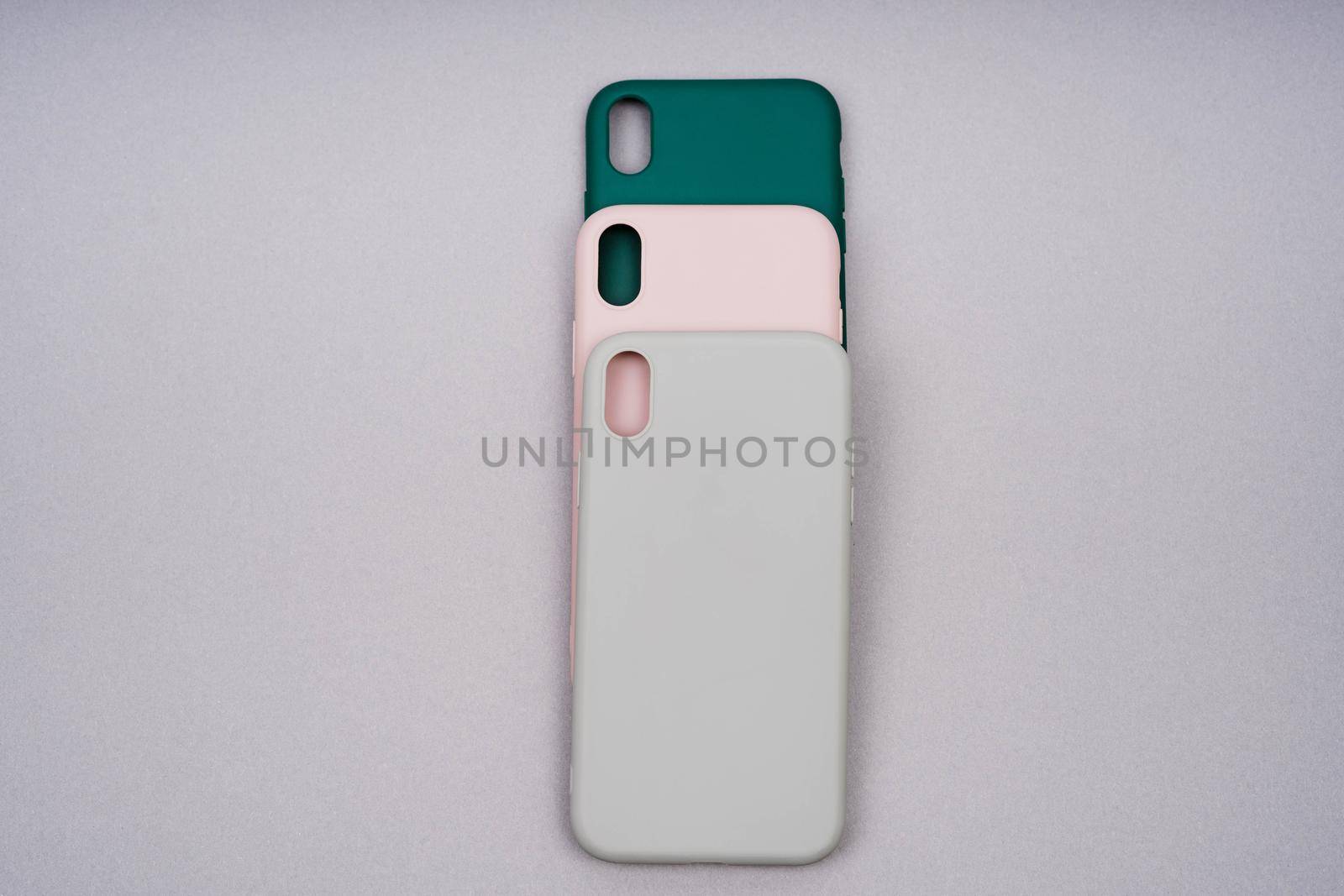 Three silicone cases for a smartphone. Covers of gray, green and powder color. A set of three covers of natural colors. Grey, green and pink smartphone cases.