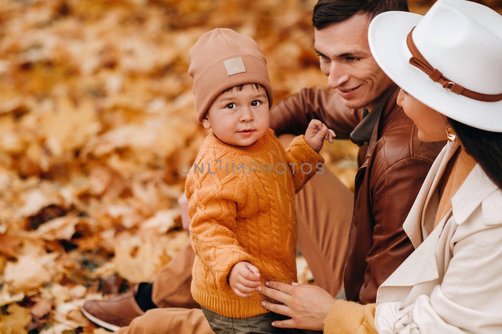 Father and mother with son walking in the autumn Park. A family walks in the Golden autumn in a nature Park