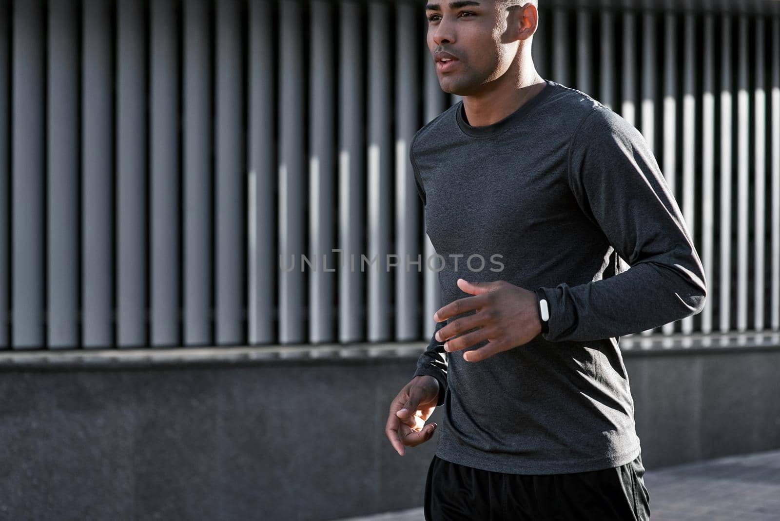 Urban sports. Latin american athlete running in city at morning by friendsstock