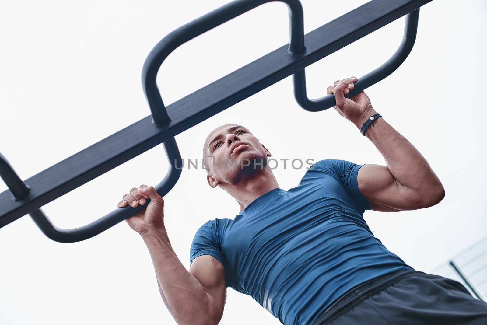 Young male jogger athlete training and doing workout outdoors in city.