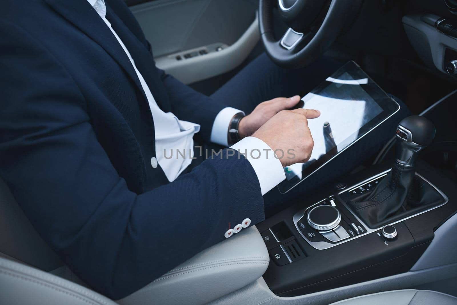 Businessman is working using his tablet in the car