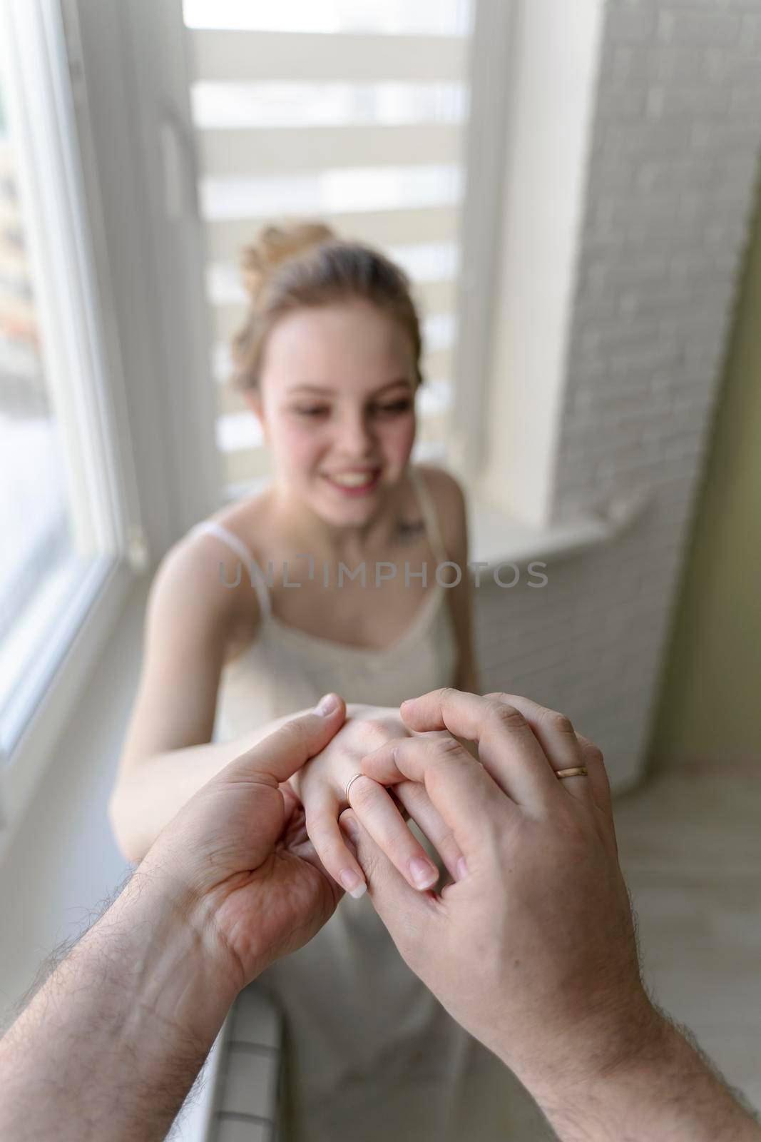 a man proposes to a beautiful young woman and puts a ring on her finger