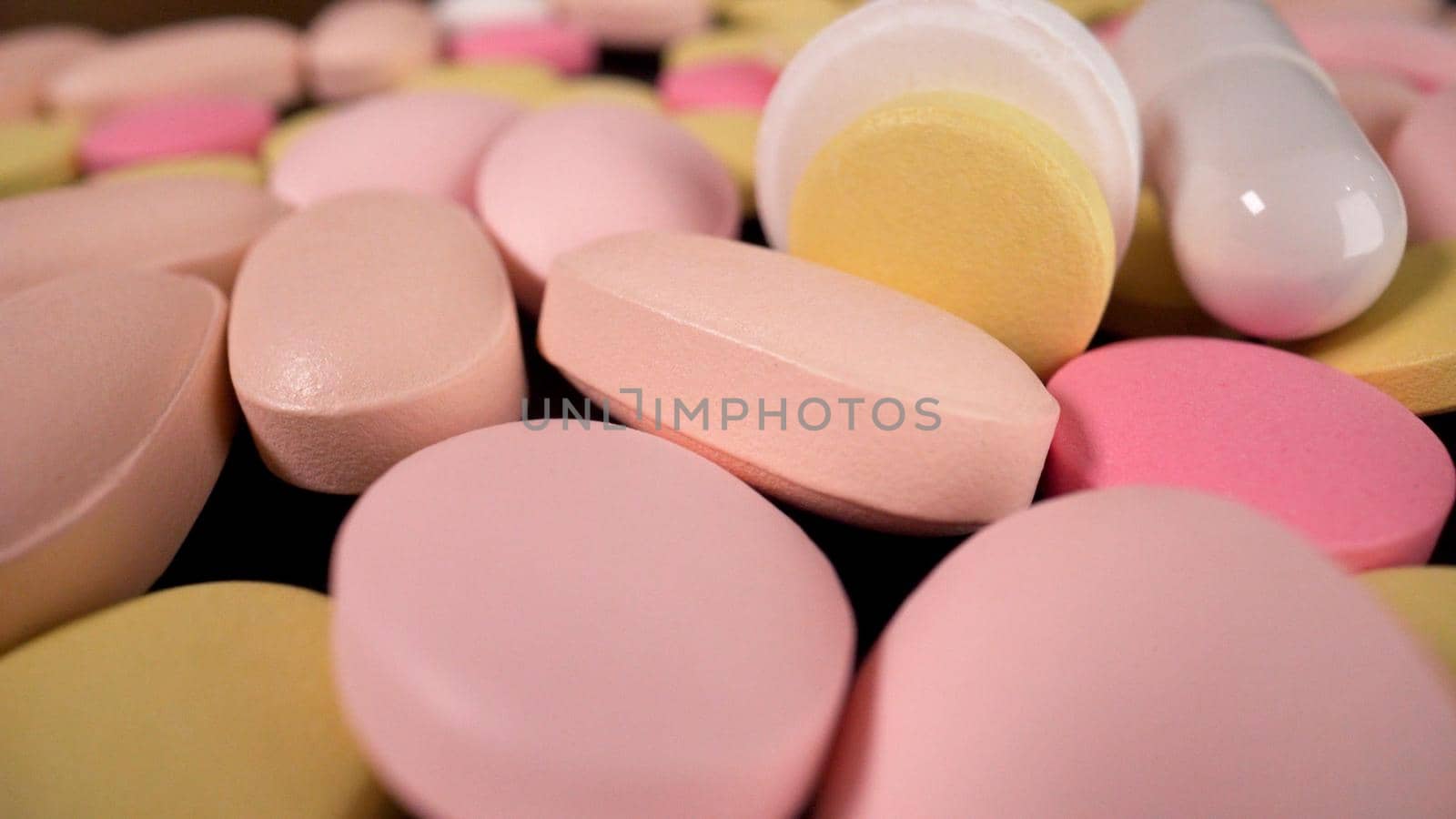 Colorful medical capsules falling on the table. Many tablets fall to the table. by Rusrussid