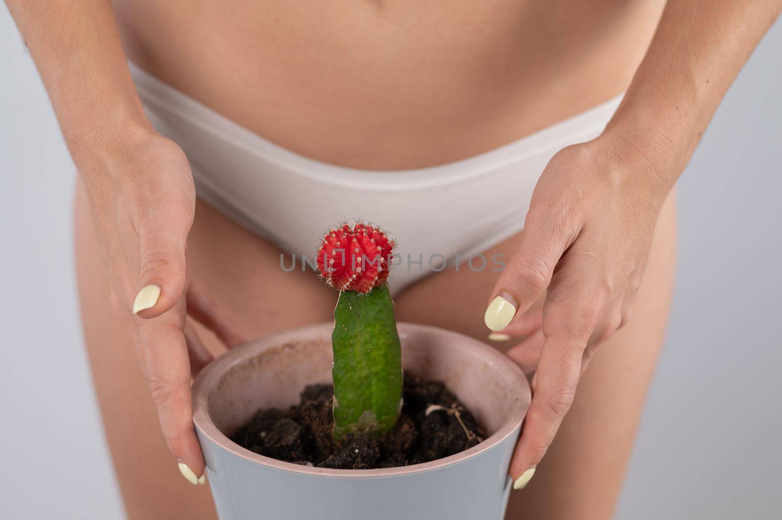 A woman in white shorts holds a cactus on a white background. by mrwed54
