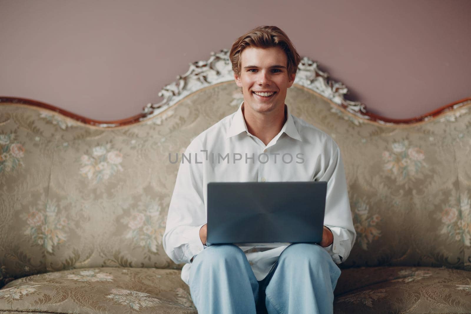 Portrait young man sitting with laptop at studio. by primipil