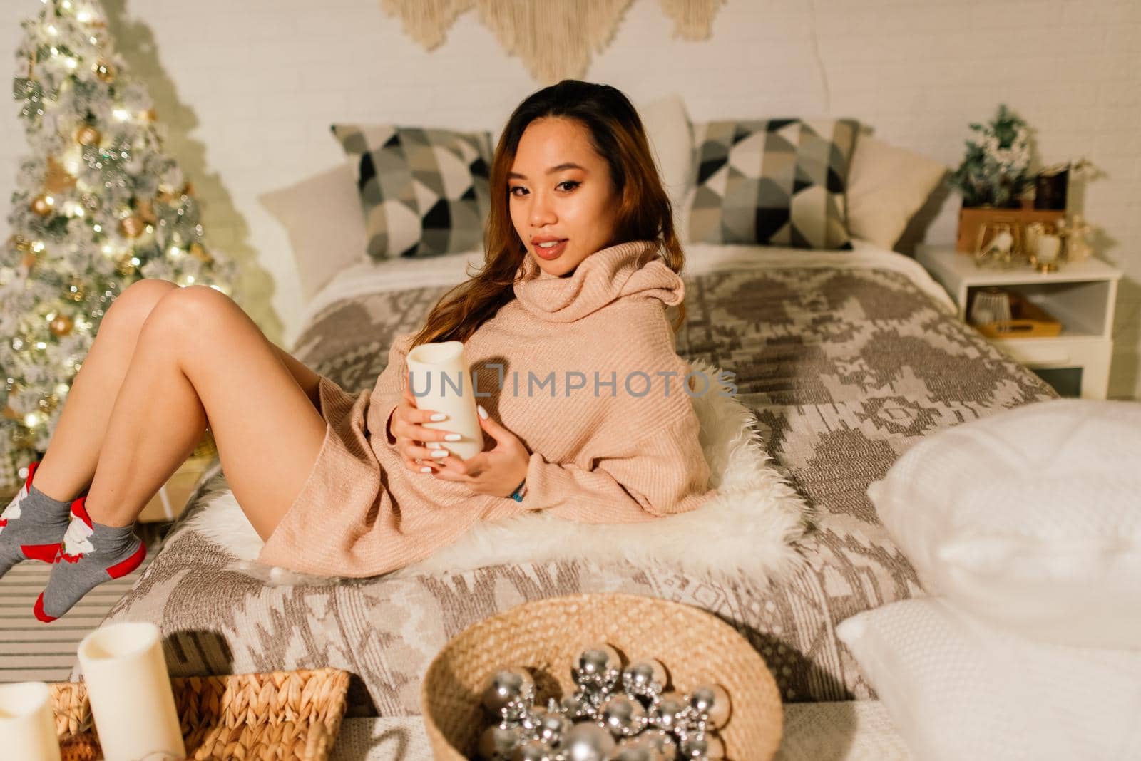 Beautiful young asian woman celebrating christmas at home, having fun while opening presents by Zelenin