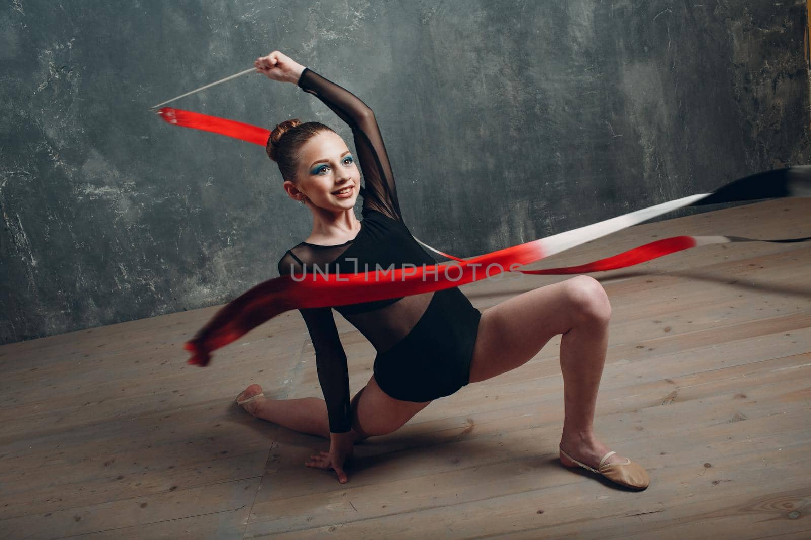 Young girl professional gymnast woman rhythmic gymnastics with ribbon at studio by primipil