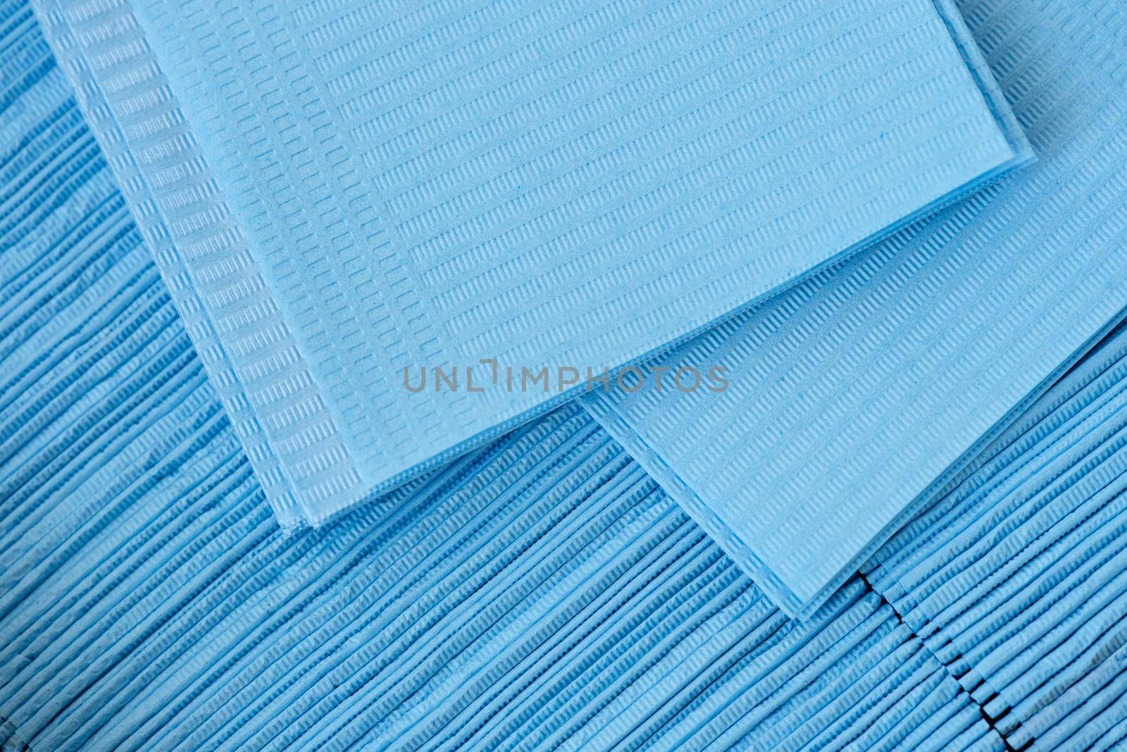 Set of medical disposable napkins for patient examination, close-up. Virus protection during a pandemic, blue paper texture