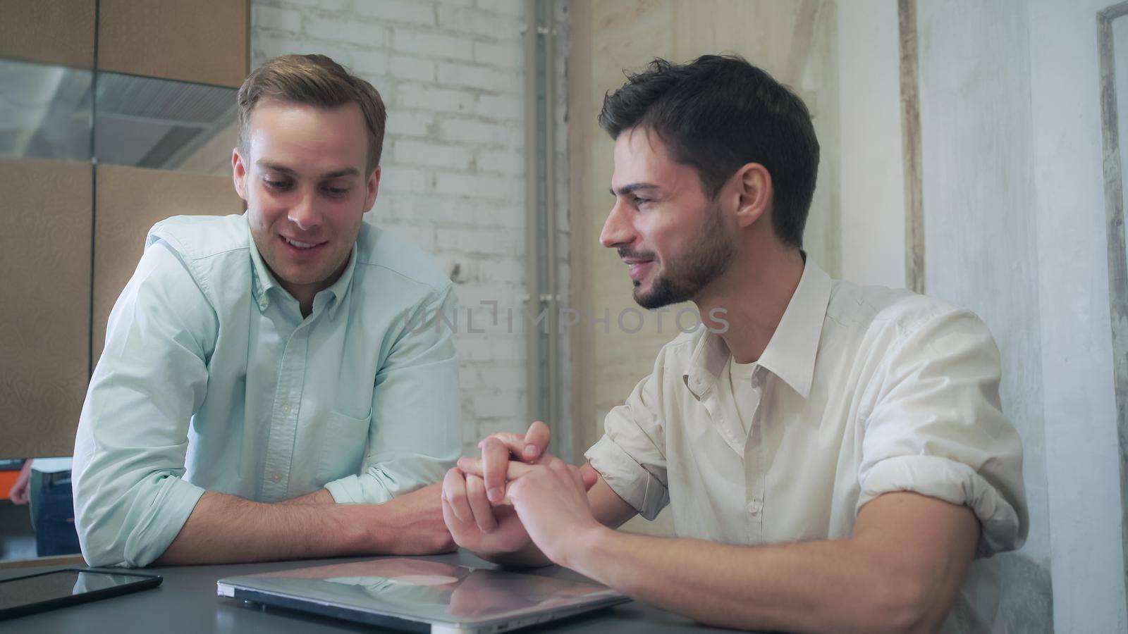 Two young man finishing project celebrating success.