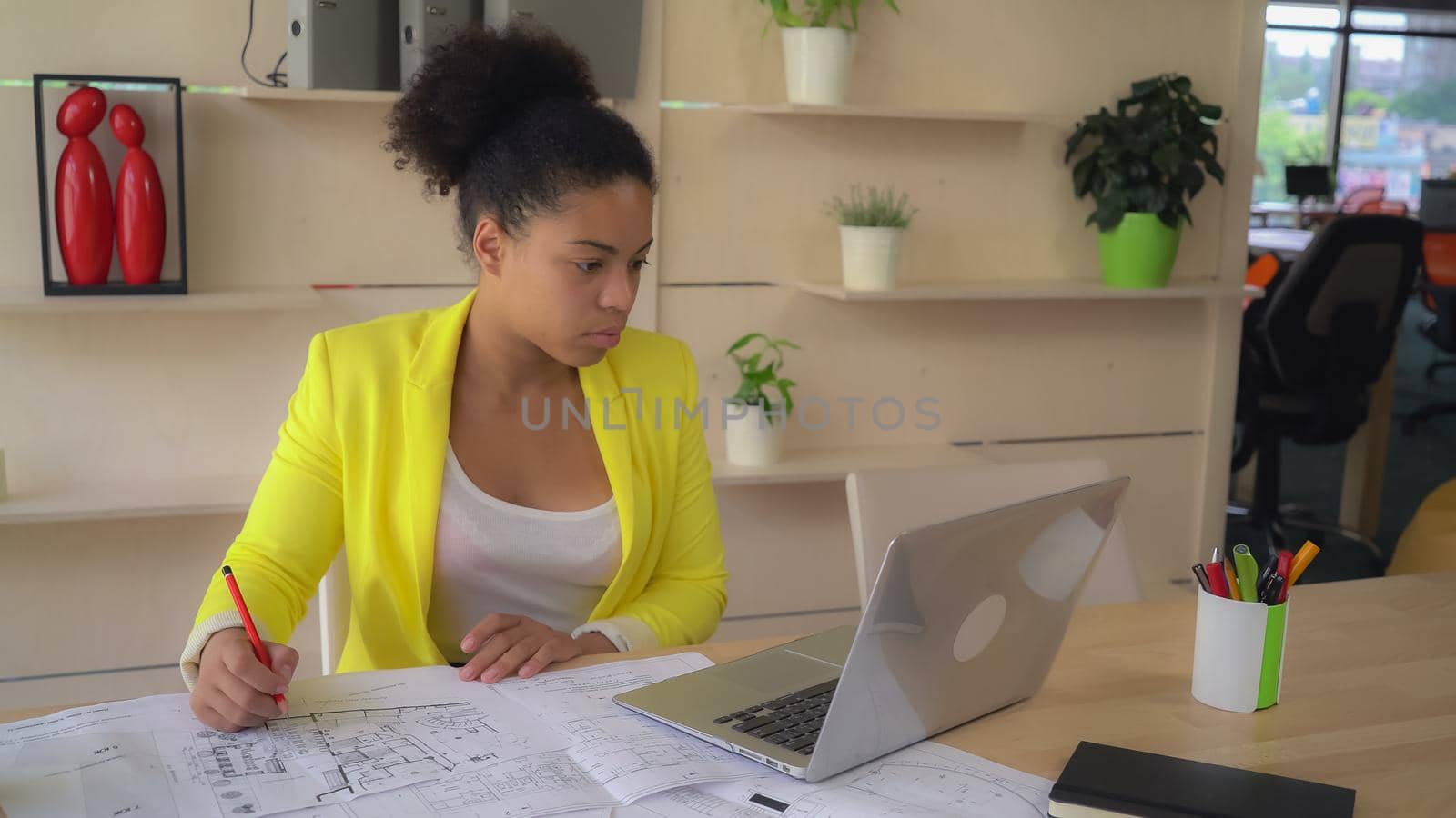 Mulatto mixed race woman at work wearing in casual yellow jacket.