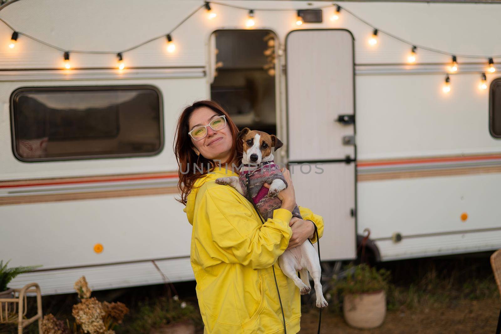Red-haired Caucasian woman hugs a dog and lives in a motor home. Travel by trailer. by mrwed54